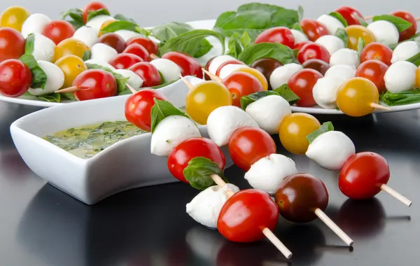 Kirschtomaten und Mozzarella auf Spießen und Vinaigrette-Sauce — Stockfoto