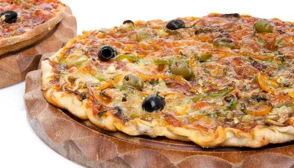 Pizzas saborosas em uma placa de madeira — Fotografia de Stock