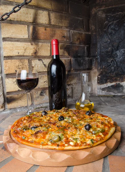 Pizza with wine and oil on a firebricks background — Stock Photo, Image