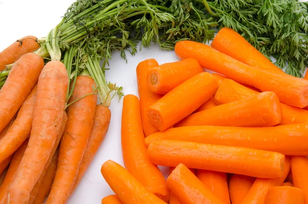 Manojo de zanahorias frescas y montón de zanahorias peladas —  Fotos de Stock