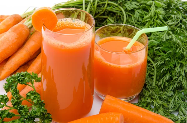 Composición con dos vasos de jugo de zanahoria y zanahorias —  Fotos de Stock