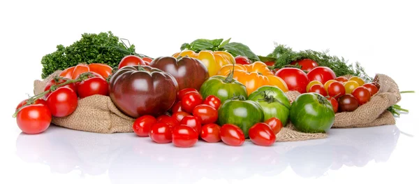 Composition of different varieties of tomatoes and herbs on a bu — Stock Photo, Image