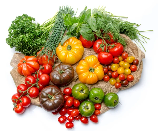 Composition of different varieties of tomatoes and herbs on a bu — Stock Photo, Image