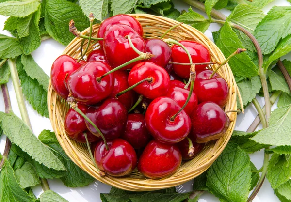Composition with cherries in a basket and mint — Stock Photo, Image