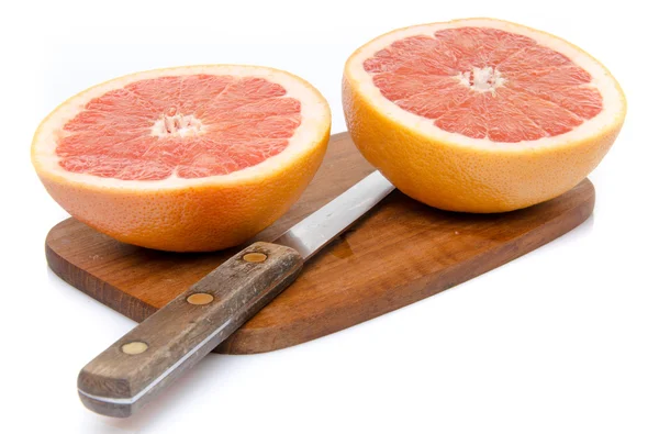 Grapefruit gesneden in de helft op een houten bord — Stockfoto