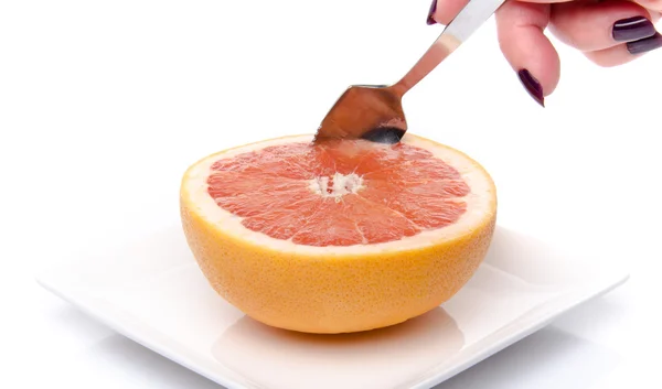 Vrouw hand nemen van een stuk van vers grapefruit met een lepel — Stockfoto