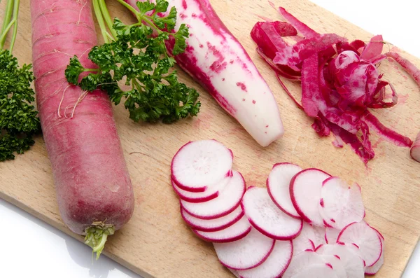 Whole and sliced red radish on a wooden cutting board — Stock Photo, Image