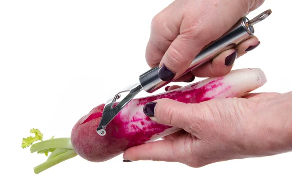 Woman's hand peeling a red radish — Stock Photo, Image