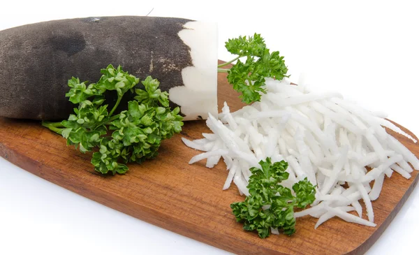 Grated black radish on a wooden board — Stock Photo, Image