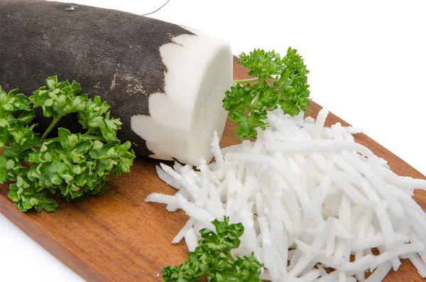 Grated black radish on a wooden board — Stock Photo, Image