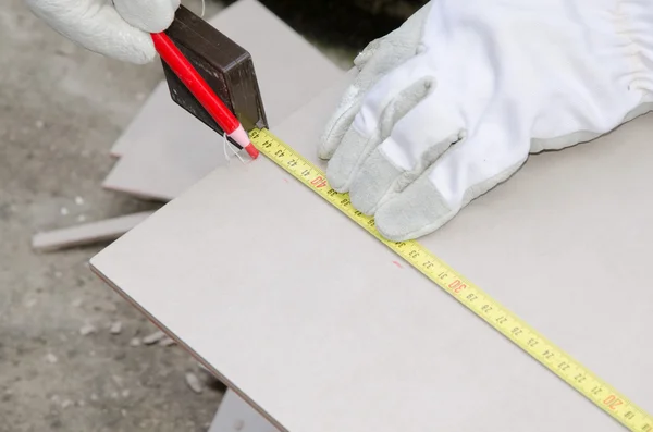 Tiler measuring tile before cutting — Stock Photo, Image