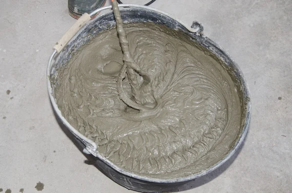 Tiler misturando adesivo de azulejo com broca de energia em um balde — Fotografia de Stock