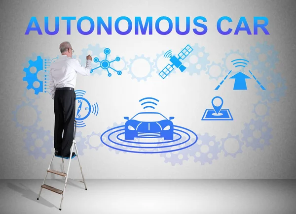 stock image Man on a ladder drawing autonomous car concept on a wall