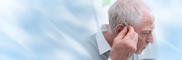 Hombre Mayor Poniendo Audífonos Pancarta Panorámica — Foto de Stock