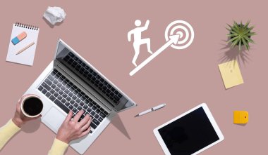 Hedef kavramının sembolü olan dizüstü bilgisayar kullanan ellerin üst görünümü