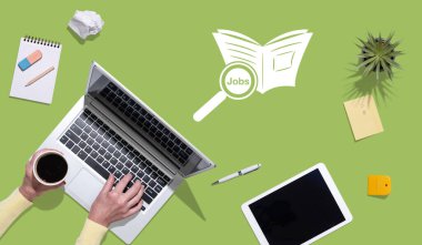 İş arama kavramına sahip dizüstü bilgisayar kullanan ellerin üst görünümü