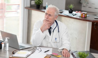 Tıp ofisinde düşünceli bir doktorun portresi.