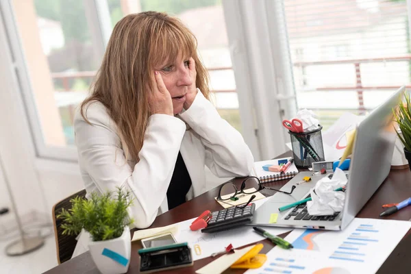 Overwerkt Volwassen Zakenvrouw Zitten Aan Een Rommelig Bureau — Stockfoto