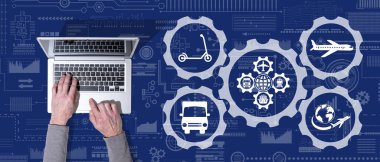 Küresel ulaşım kavramının sembolü olan dizüstü bilgisayar kullanan ellerin üst görünümü