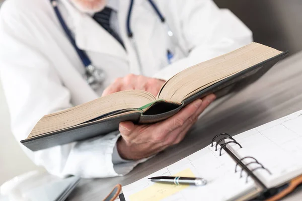 Γιατρός Διαβάζει Ένα Εγχειρίδιο Στο Ιατρικό Γραφείο — Φωτογραφία Αρχείου