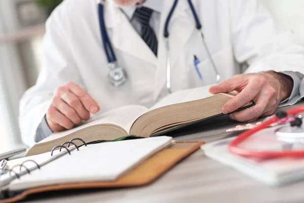 Γιατρός Διαβάζει Ένα Εγχειρίδιο Στο Ιατρικό Γραφείο — Φωτογραφία Αρχείου