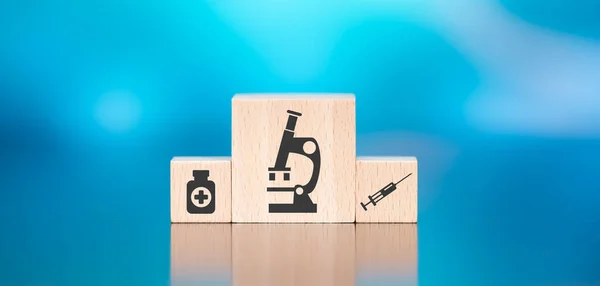 青い背景に医学研究の概念の象徴と木製のブロック — ストック写真