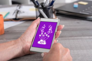 Kadın eli akıllı bir telefonu kavramsal olarak tutuyor.