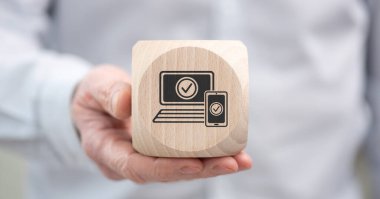 2fa kavramının sembolü olan ahşap bir küpü tutan el.