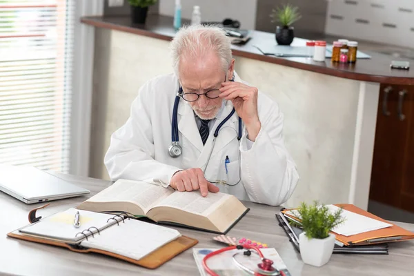 Senior Doctor Reading Textbook Medical Office — Stock Photo, Image