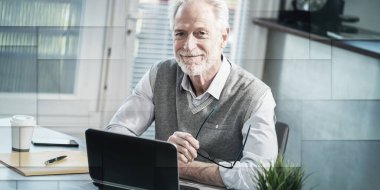 Ofiste oturan gülümseyen kıdemli işadamının portresi, geometrik desen