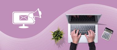 E- posta pazarlama kavramının sembolü olan dizüstü bilgisayar kullanan ellerin üst görünümü