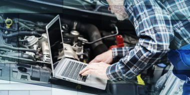 Araba motoru ve geometrik desenleri kontrol etmek için dizüstü bilgisayar kullanan araba tamircisi