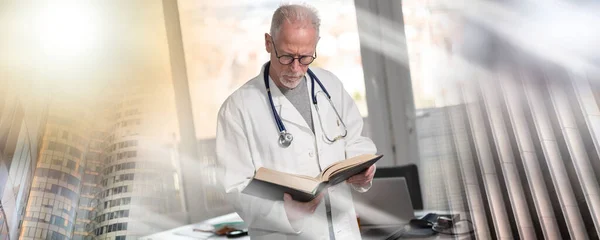 Ανώτερος Γιατρός Που Διαβάζει Ένα Βιβλίο Στην Κλινική Πολλαπλή Έκθεση — Φωτογραφία Αρχείου