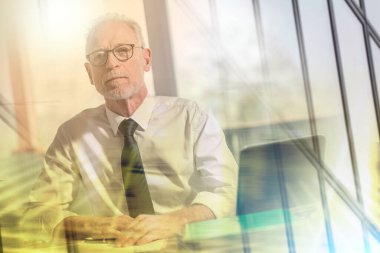 Ofiste oturan olgun işadamı portresi; birden fazla pozlama