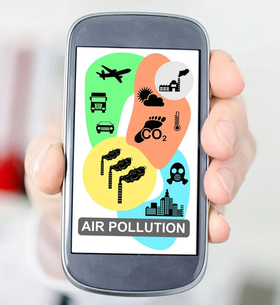 Hava kirliliği kavramına sahip akıllı bir telefonu tutmak