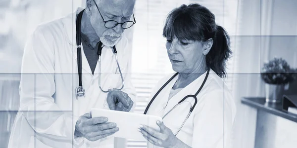 Two Mature Doctors Discussing Medical Report Digital Tablet Geometric Pattern — Stockfoto