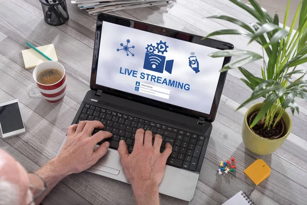 Man using a laptop with live streaming concept on the screen