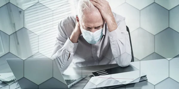 Desperate senior businessman wearing medical face mask with hand on his head; concept of economic crisis due to the coronavirus outbreak, geometric pattern