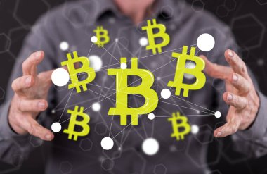 Arka planda bir adamın elleri arasında Bitcoin kavramı