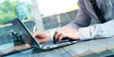 Businessman using a laptop in office, geometric pattern