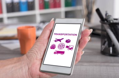 Ulaşım konsepti olan akıllı telefonu tutan bir kadın.