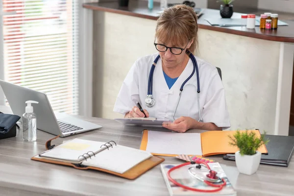 Female Doctor Taking Notes Clipboard Medical Office — Stock Photo, Image