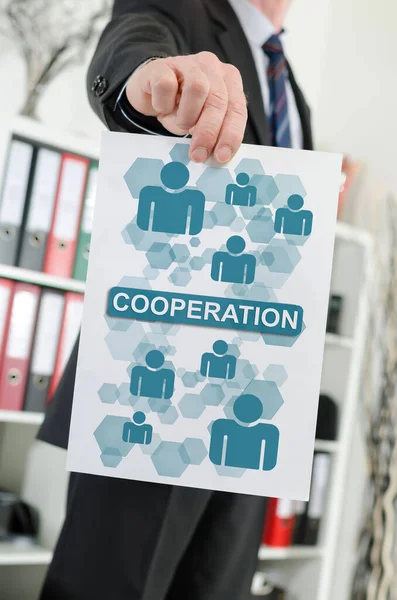 Bir iş adamı tarafından tutulan işbirliği konseptini gösteren kağıt.