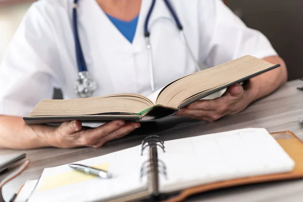 Γυναίκα Γιατρός Διαβάζει Ένα Βιβλίο Στο Ιατρικό Γραφείο — Φωτογραφία Αρχείου