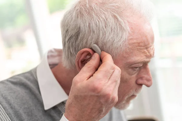 補聴器を置くシニア男性 — ストック写真