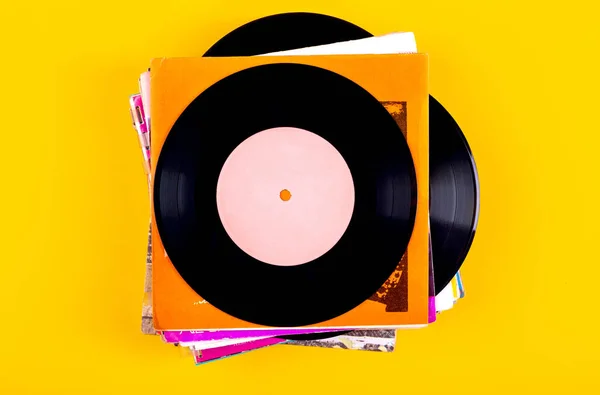 Stack Old Vinyl Records Yellow Background Top View — стоковое фото