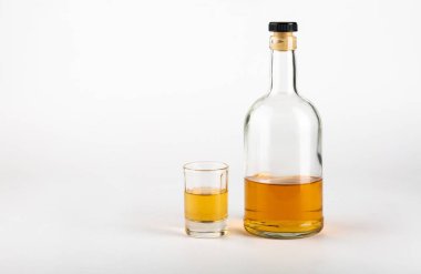 Beyaz arka planda cam ve bir şişe alkol. Alkolizm kavramı..