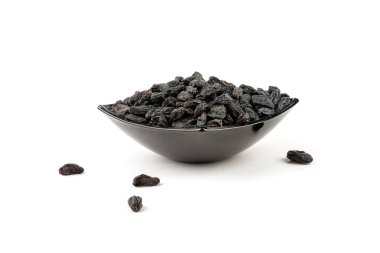 Raisins in a dark plate isolated on a white background.