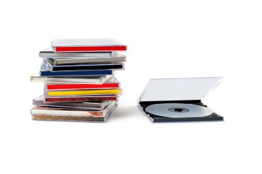 Açık bir kutuda CD ve beyaz arkaplanda bir yığın disk