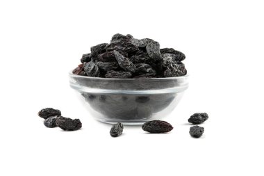 Beyaz arka planda izole edilmiş bir tabakta koyu kuru üzümler..